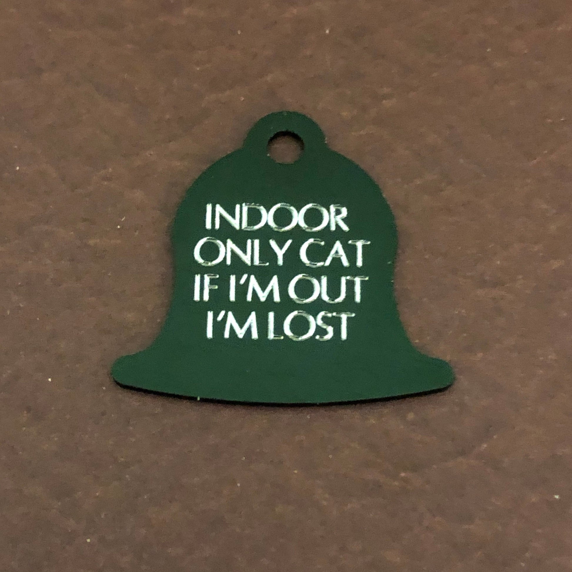 Small green bell tag that says: Indoor only cat If I&#39;m out I&#39;m lost. All engraved in capital letters.