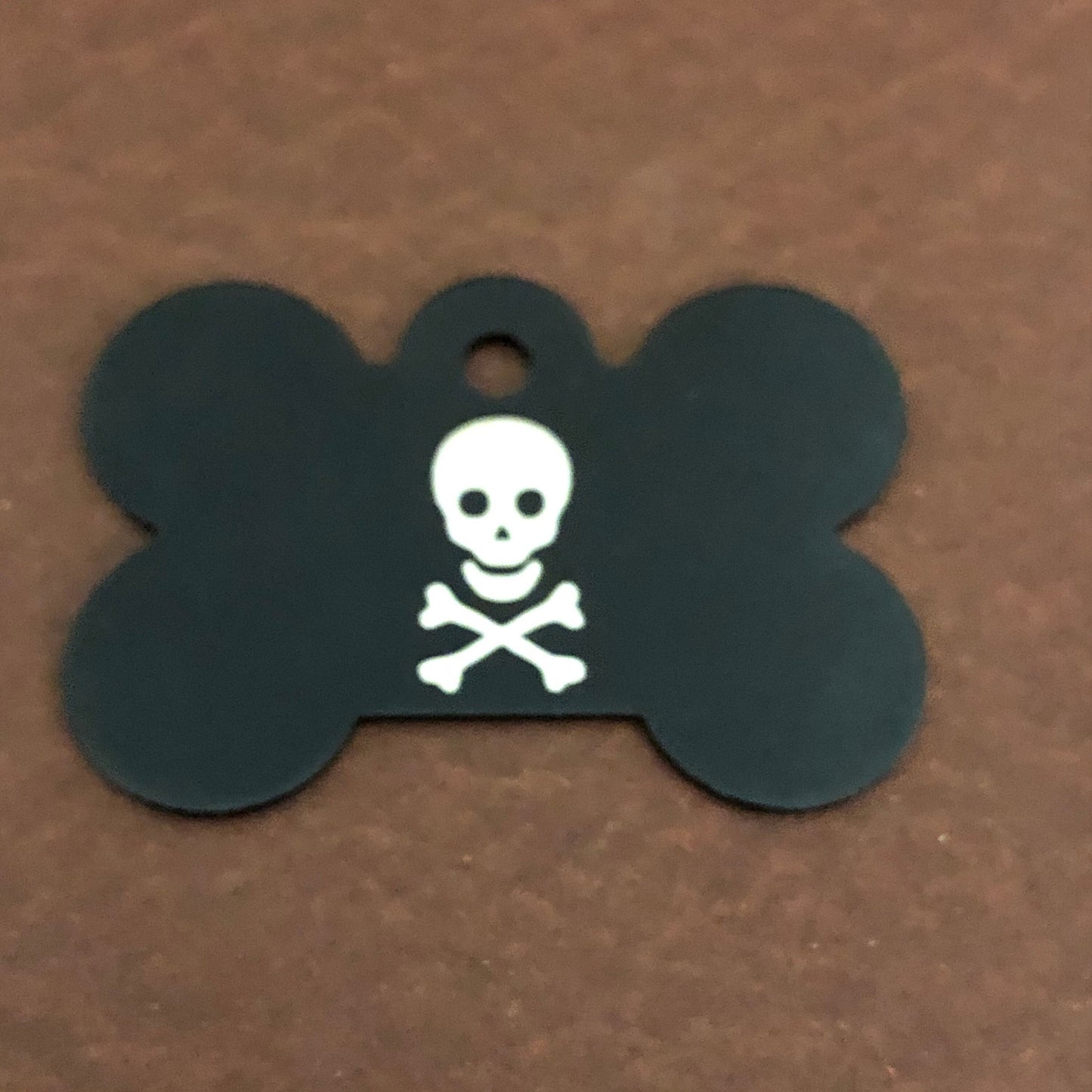 It is a large black bone aluminum tag with a skull and bones on it.
The Tag measures approximately 1 9/16&quot;W x 1 1/16&quot;H.