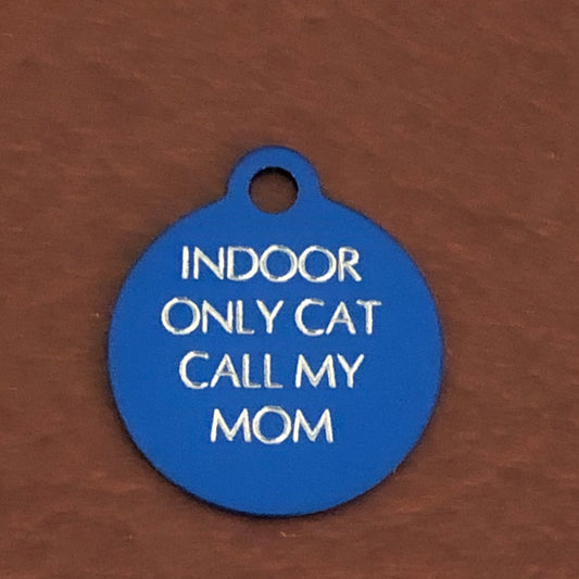 Small blue circle tag that says: Indoor only cat call my mom. All engraved in capital letters.