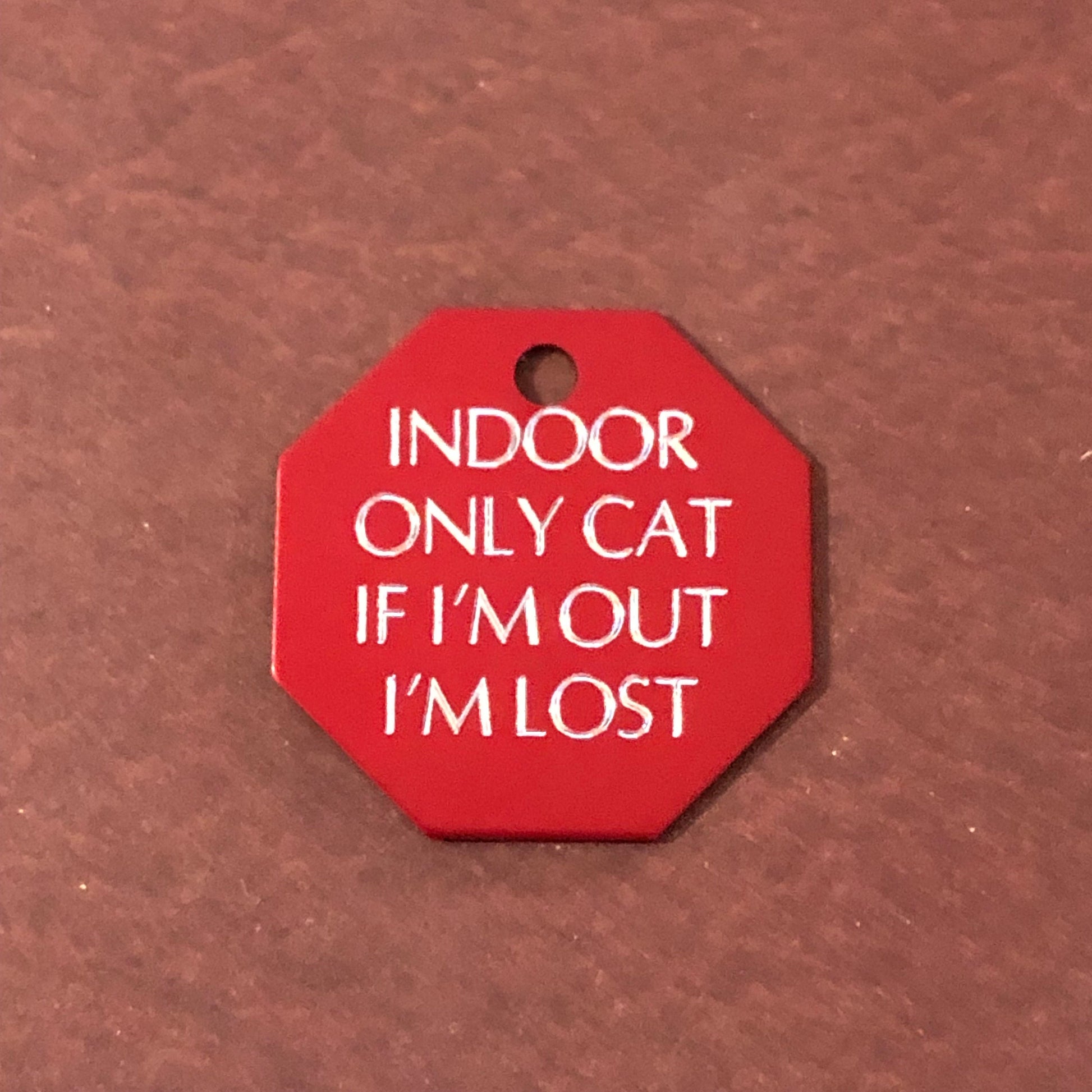 Large red stop sign tag that says: Indoor only cat If I&#39;m out I&#39;m lost. All engraved in capital letters.