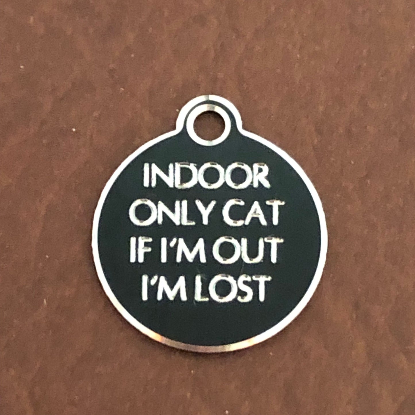 Small Hi-LITE black circle tag that says: Indoor only cat If I&#39;m out I&#39;m lost. All engraved in capital letters.